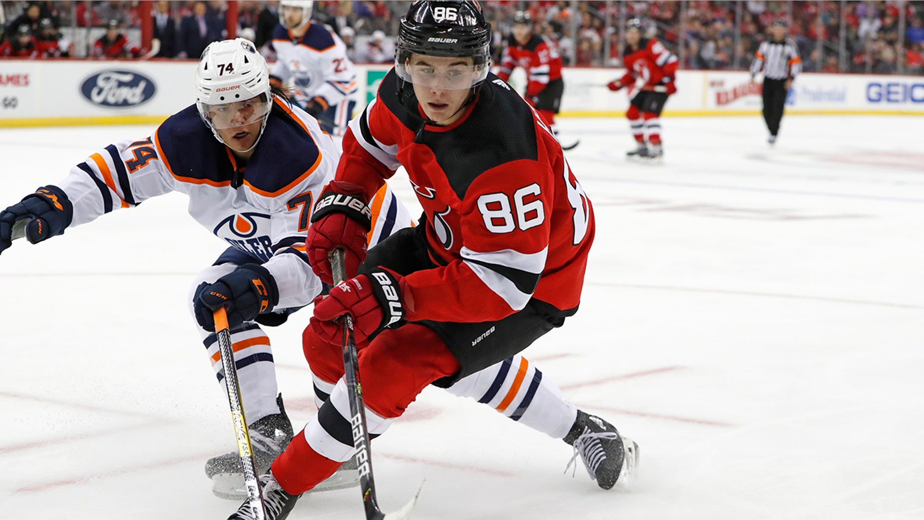 Edmonton Oilers defenseman Ethan Bear (74) defends New Jersey Devils center Jack Hughes (86) during the second period of an NHL hockey game Thursday, Oct. 10, 2019, in Newark, N.J. (AP Photo/Kathy Willens)