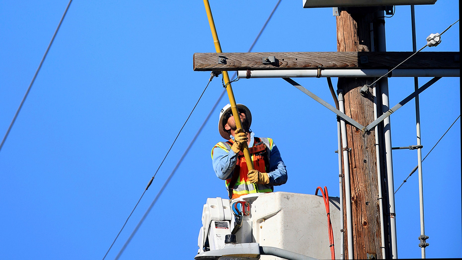 A Pacific Gas & Electric Co. crew trips a segment of power lines in Santa Rosa, Calif., Wednesday, Oct. 23, 2019, that will make it easier to restore power. The power was shut off by PG&E due to the high fire danger. (Kent Porter/The Press Democrat via AP)