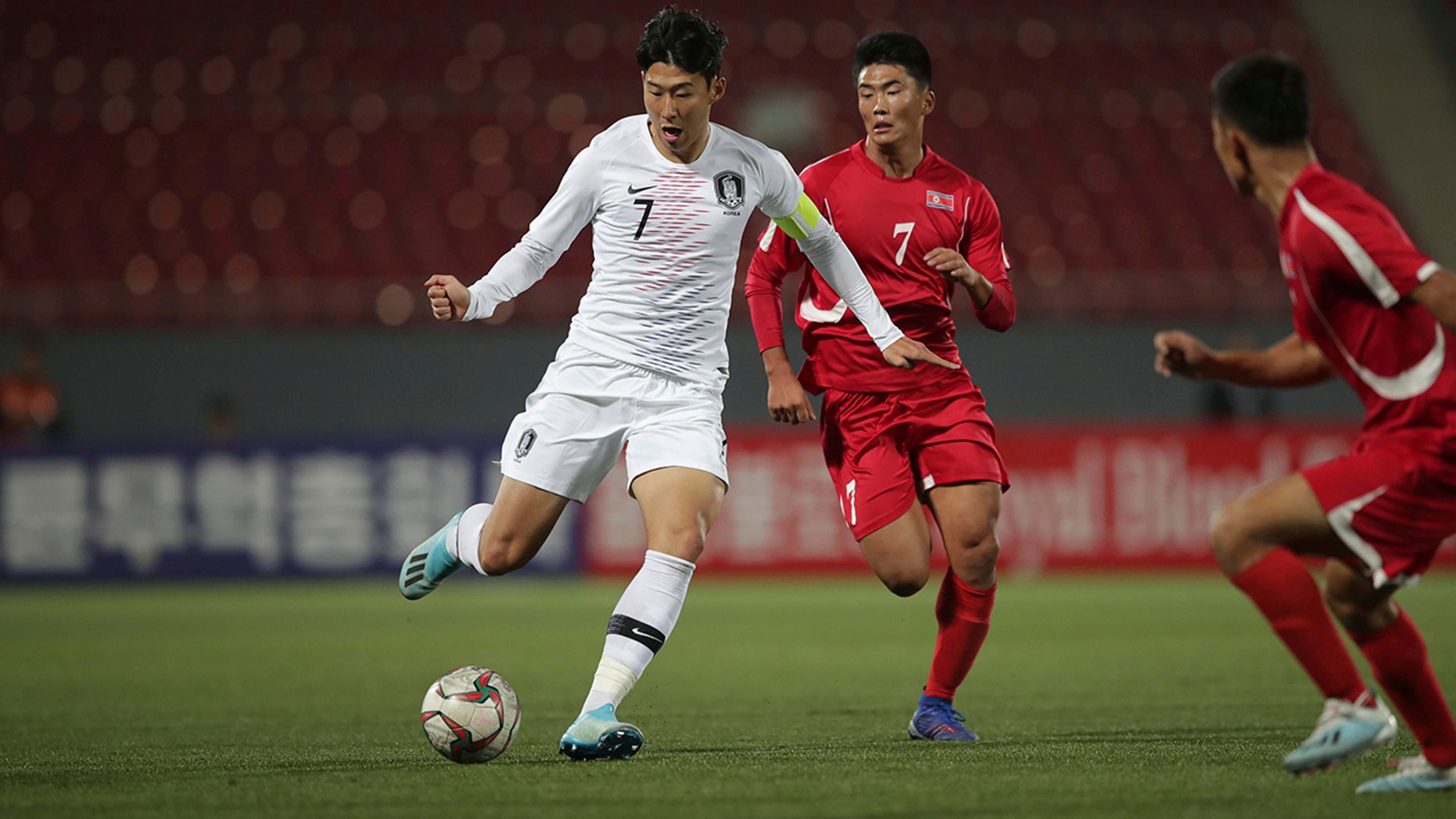 In this photo provided by the Korea Football Association, South Korea's Son Heung-min, left, fights for the ball against North Korea's Han Kwang Song during their Asian zone Group H qualifying soccer match for the 2022 World Cup at Kim Il Sung Stadium in Pyongyang, North Korea, Tuesday, Oct. 15, 2019. (The Korea Football Association via AP).