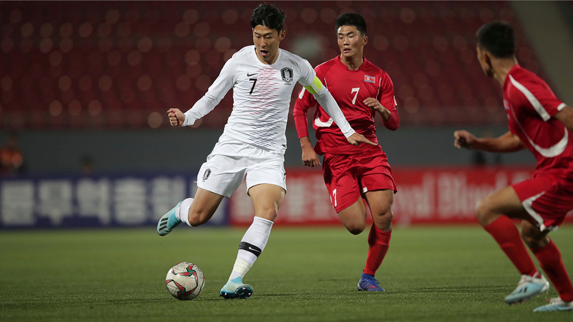 In this photo provided by the Korea Football Association, South Korea's Son Heung-min, left, fights for the ball against North Korea's Han Kwang Song during their Asian zone Group H qualifying soccer match for the 2022 World Cup at Kim Il Sung Stadium in Pyongyang, North Korea, Tuesday, Oct. 15, 2019. (The Korea Football Association via AP).