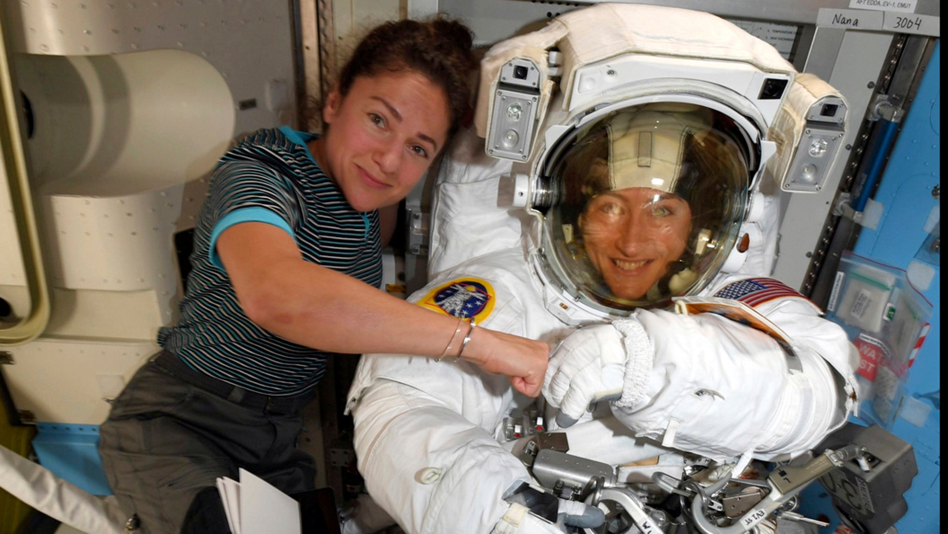 FILE - In this image released Friday, Oct. 4, 2019, by NASA, astronauts Christina Koch, right, and, Jessica Meir pose for a photo on the International Space Station. NASA has moved up the first all-female spacewalk to Thursday, Oct. 17, 2019, or Friday because of a power system failure at the International Space Station. (NASA via AP)