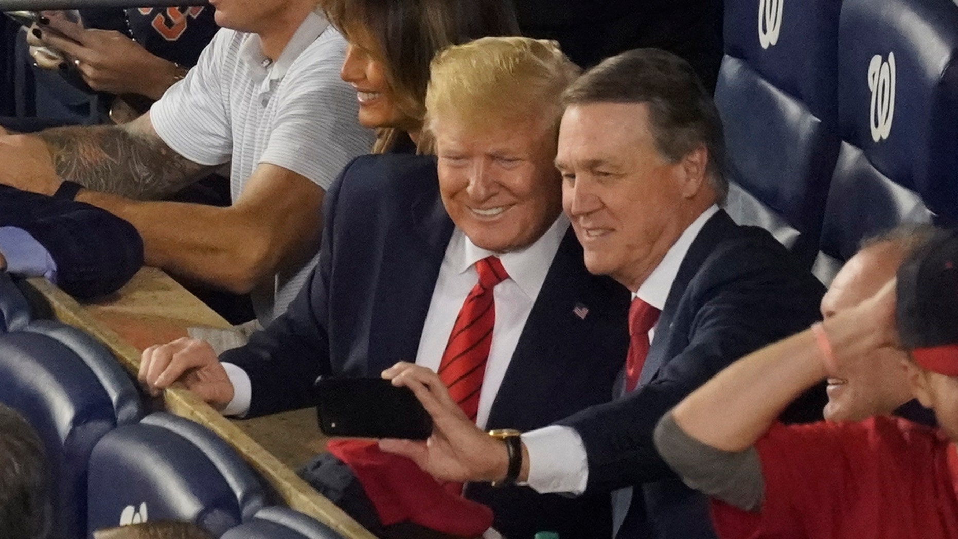 Sen. David Perdue, R-Ga., takes a selfie with President Donald Trump during the seventh inning of Game 5 of the baseball World Series between the Houston Astros and the Washington Nationals Sunday, Oct. 27, 2019, in Washington. (AP Photo/Pablo Martinez Monsivais)