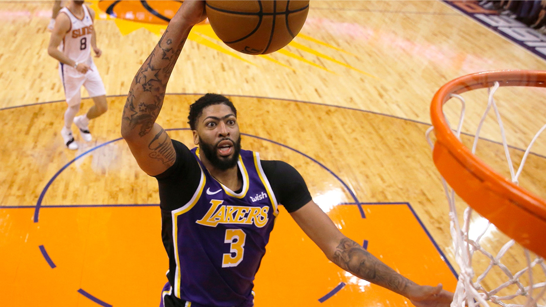 Los Angeles Lakers forward Anthony Davis scores against the Phoenix Suns during the second half during an NBA basketball game Tuesday, Nov. 12, 2019, in Phoenix. (AP Photo/Rick Scuteri)