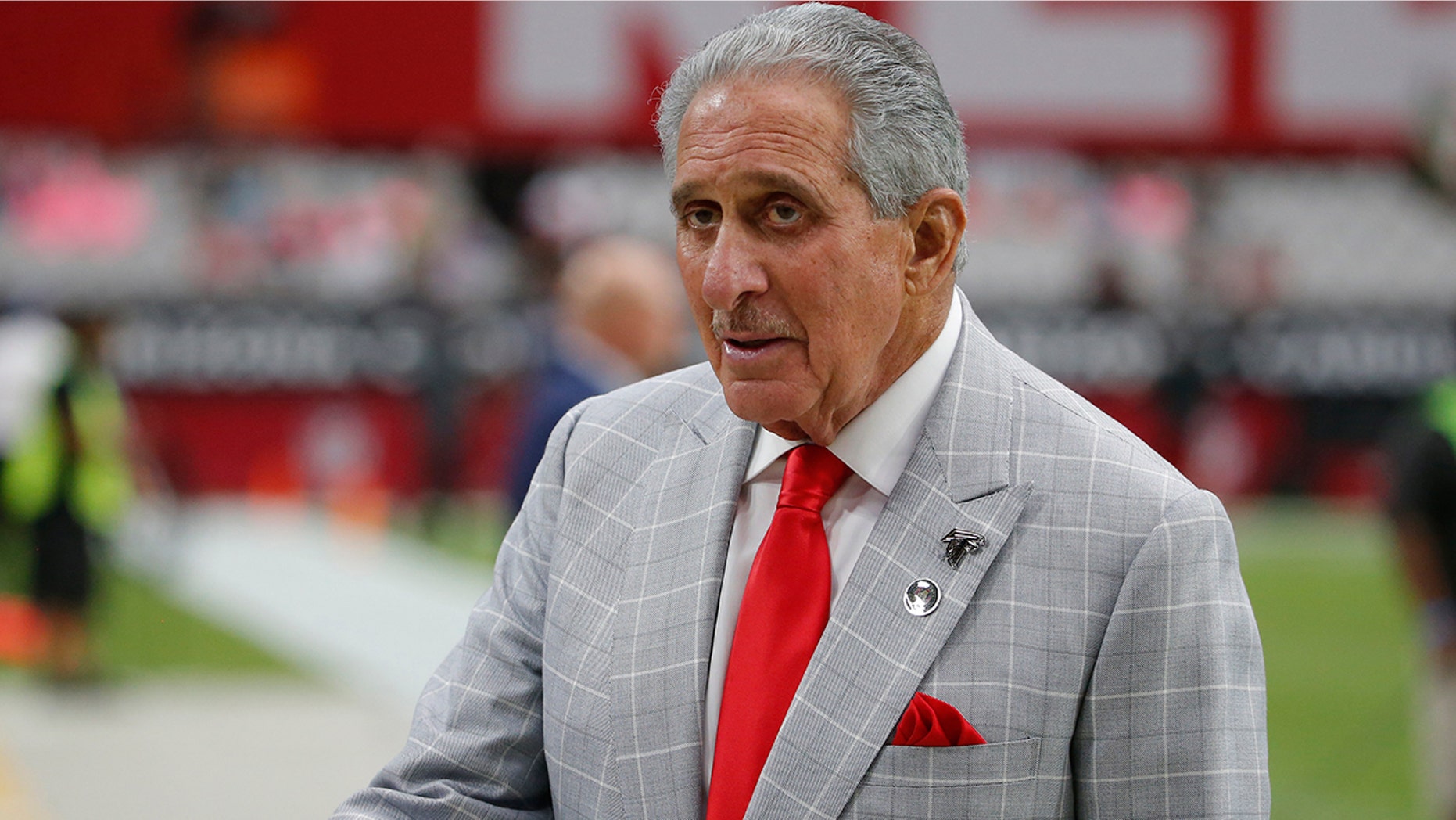 FILE - In this Oct. 13, 2019, file photo, Atlanta Falcons owner Arthur Blank stands on the field prior to an NFL football game against the Arizona Cardinals, in Glendale, Ariz. Blank is making his first major drive into international philanthropy. The Arthur M. Blank Family Foundation is expected to announce Thursday, Nov. 14, 2019, that it's donating $6.8 million to the group CARE. (AP Photo/Rick Scuteri, File)