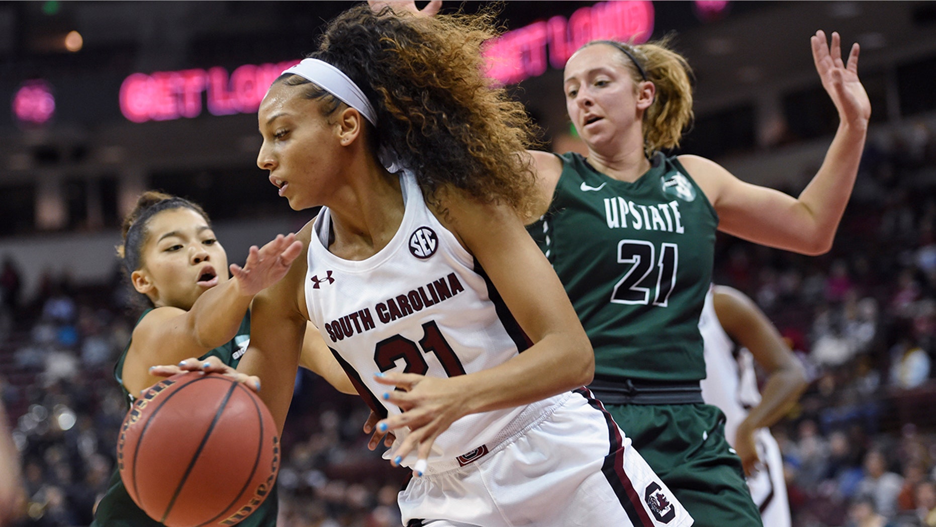 South Carolina's Harrigan Herbert (21) drives along the baseline while defended by South Carolina-Upstate's Riley Popplewell (21) and Maya Timberlake during the first half of an NCAA college basketball game Thursday, Nov. 21, 2019, in Columbia, S.C. (AP Photo/Richard Shiro)