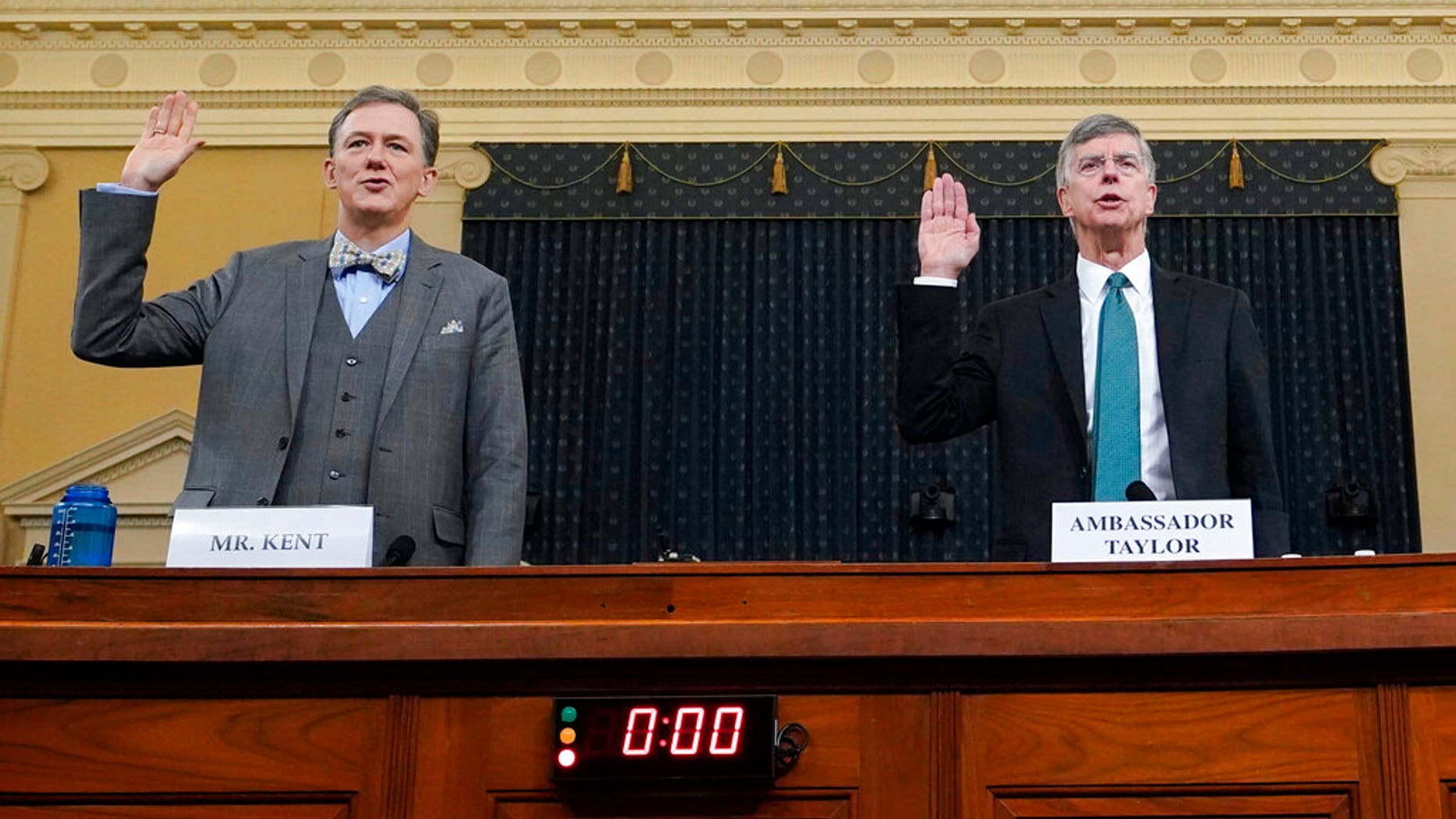 Career Foreign Service officer George Kent and top U.S. diplomat in Ukraine William Taylor, right, are sworn in to testify during the first public impeachment hearing of the House Intelligence Committee on Capitol Hill, Wednesday Nov. 13, 2019, in Washington. (Joshua Roberts/Pool via AP)