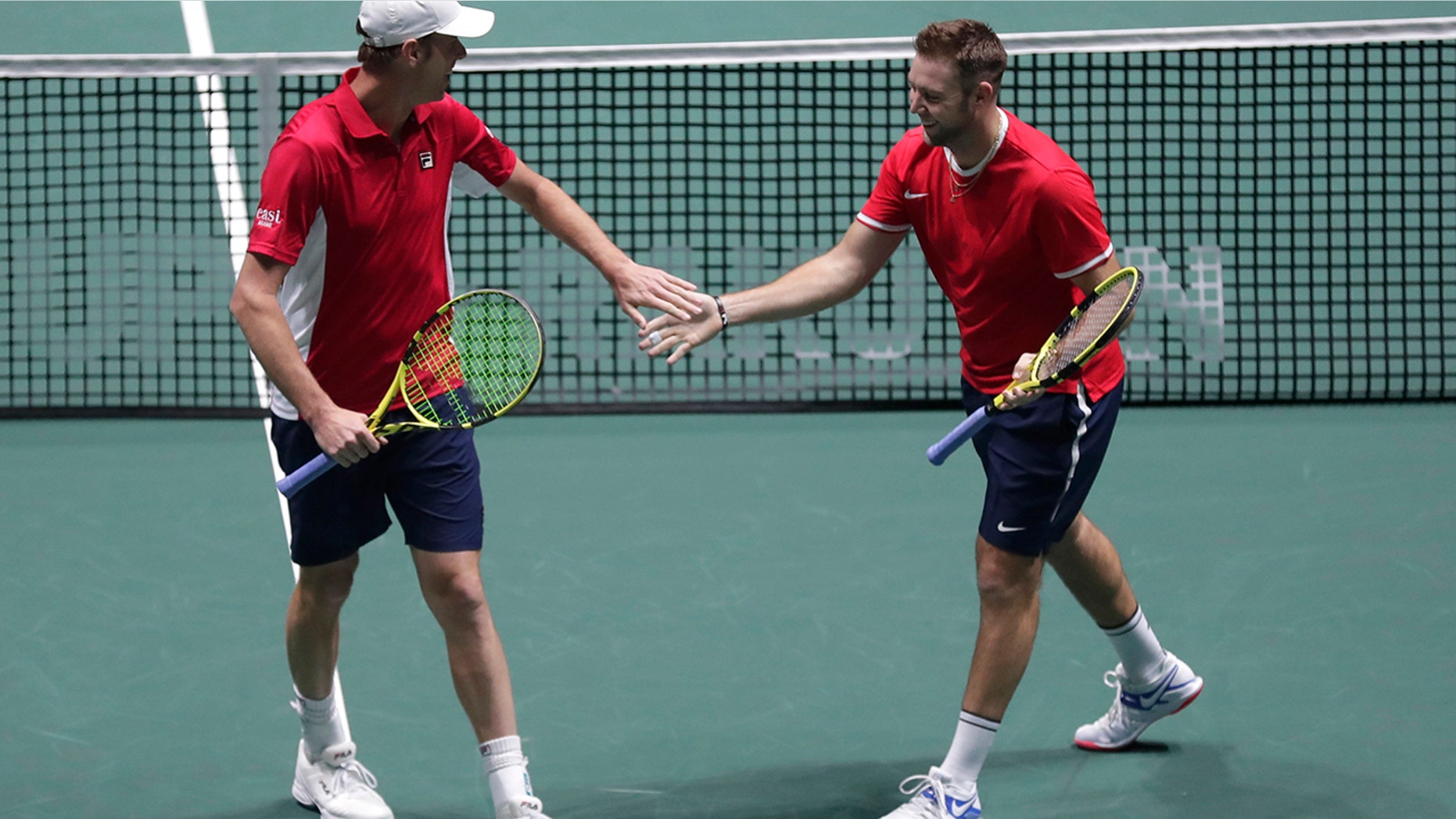 US Sam Querrey, right, and Jack Sock celebrate a point against Italy's Simone Bolelli and Fabio Fognini during their Davis Cup tennis match in Madrid, Spain, Thursday, Nov. 21, 2019. (AP Photo/Manu Fernandez)