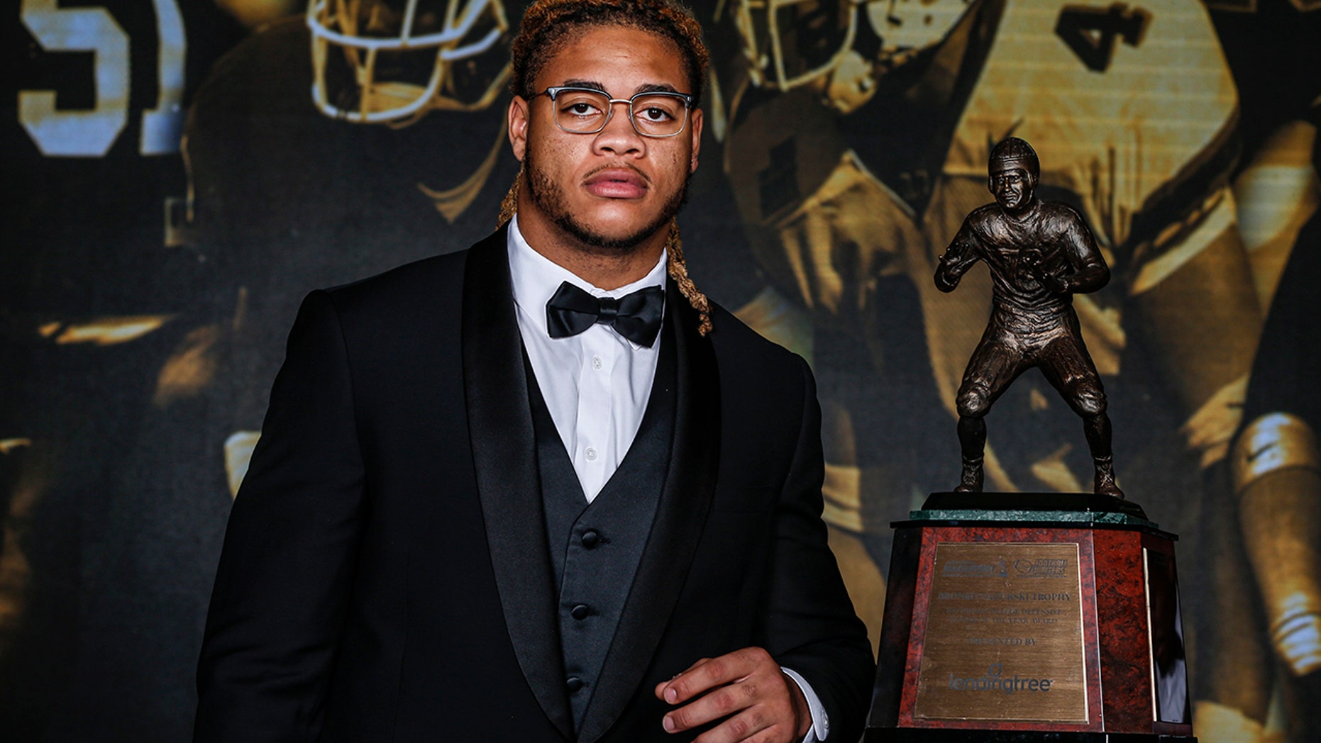 Ohio State defensive end Chase Young poses with the The 2019 Bronko Nagurski Award before the awards banquet in Charlotte, N.C., Monday, Dec. 9, 2019. (AP Photo/Nell Redmond)