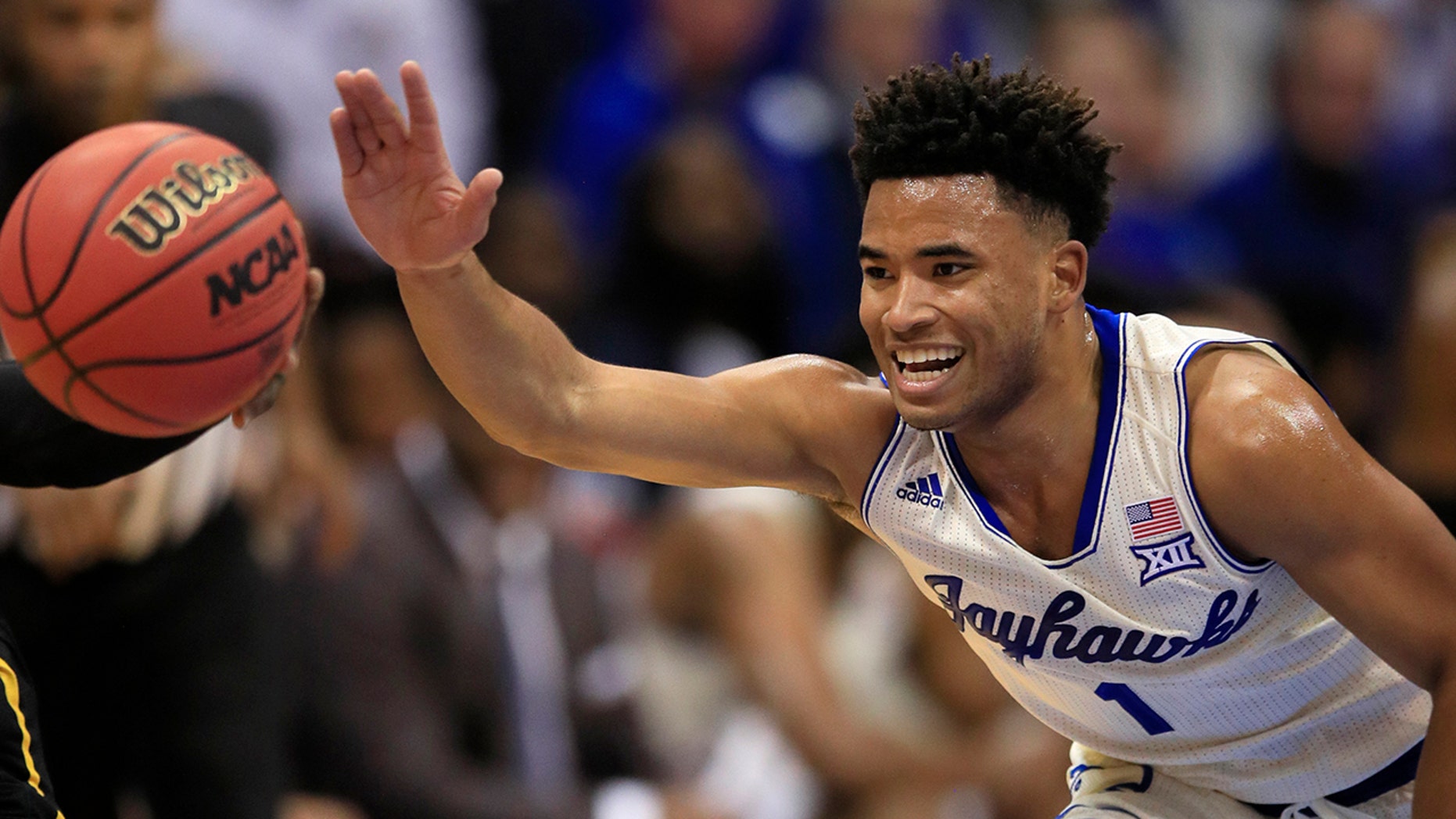 Kansas guard Devon Dotson (1) reaches for a loose ball during the first half of an NCAA college basketball game against Milwaukee in Lawrence, Kan., Tuesday, Dec. 10, 2019. (AP Photo/Orlin Wagner)