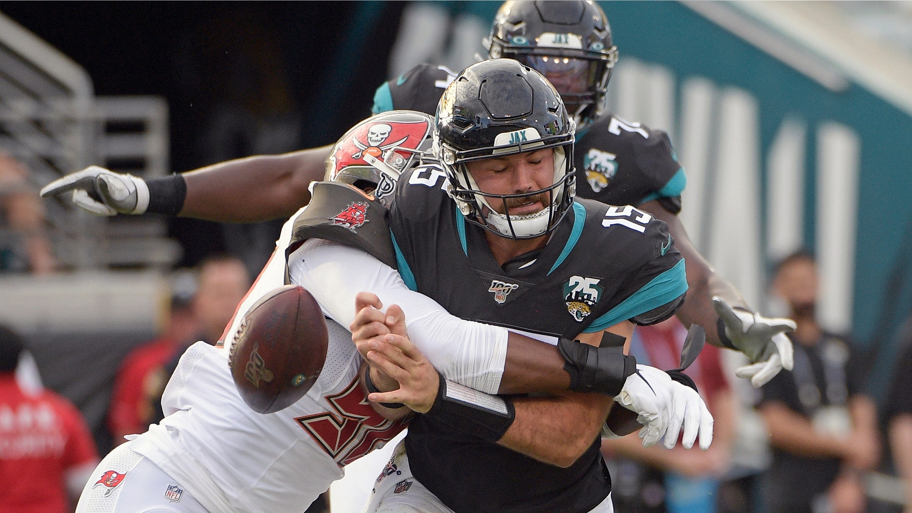 Tampa Bay Buccaneers linebacker Sam Acho, left, forces a fumble as he sacks Jacksonville Jaguars quarterback Gardner Minshew (15) during the second half of an NFL football game, Sunday, Dec. 1, 2019, in Jacksonville, Fla. (AP Photo/Phelan M. Ebenhack)