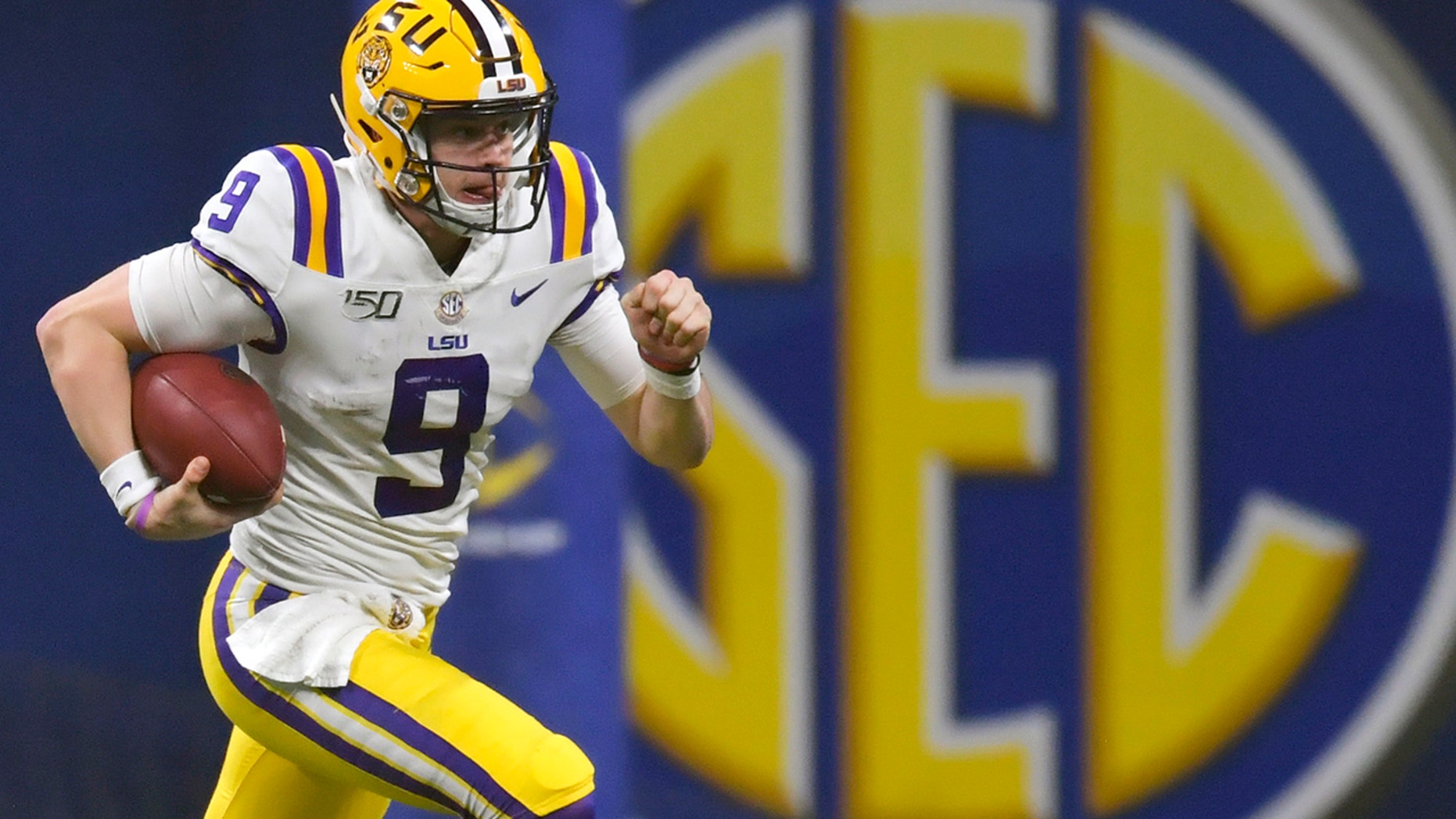 FILE - In this Dec. 7, 2019, file photo, LSU quarterback Joe Burrow (9) runs against Georgia during the second half of the Southeastern Conference championship NCAA college football game, in Atlanta. Burrow is a unanimous selection as the offensive player of the year on The Associated Press All-Southeastern Conference football team, Monday, Dec. 9, 2019. (AP Photo/Mike Stewart, File)
