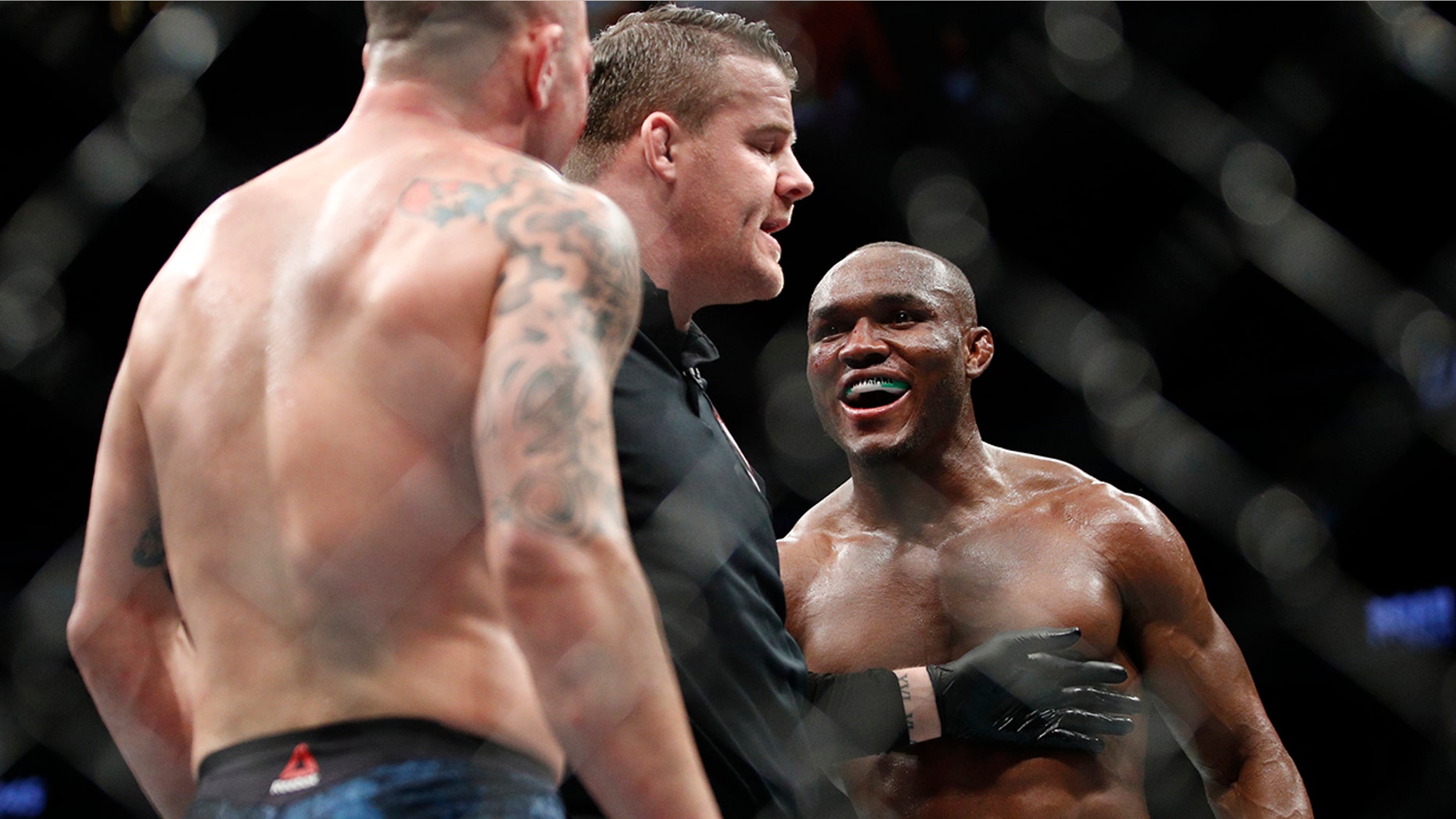 Kamaru Usman, right, taunts Colby Covington in a mixed martial arts welterweight championship bout at UFC 245, Saturday, Dec. 14, 2019, in Las Vegas. (AP Photo/John Locher)