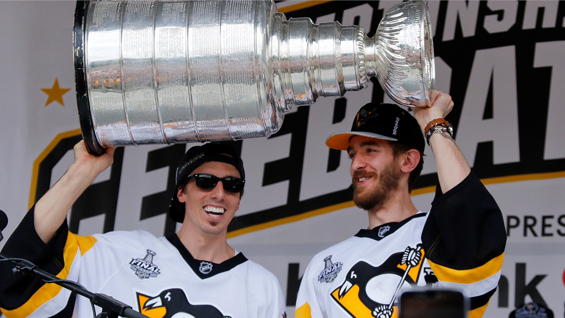 FILE - In this Wednesday, June 14, 2017, file photo, Pittsburgh Penguins goalies Marc-Andre Fleury, left, and Matt Murray hold the Stanley Cup on stage after riding in the Stanley Cup victory parade in Pittsburgh. Managing top goaltenders’ schedules is the NHL’s version of load management. Each of the past five Stanley Cup-winning goalies started fewer than 60 games in the regular season, along with three of the past five runners up. (AP Photo/Gene J. Puskar, File)