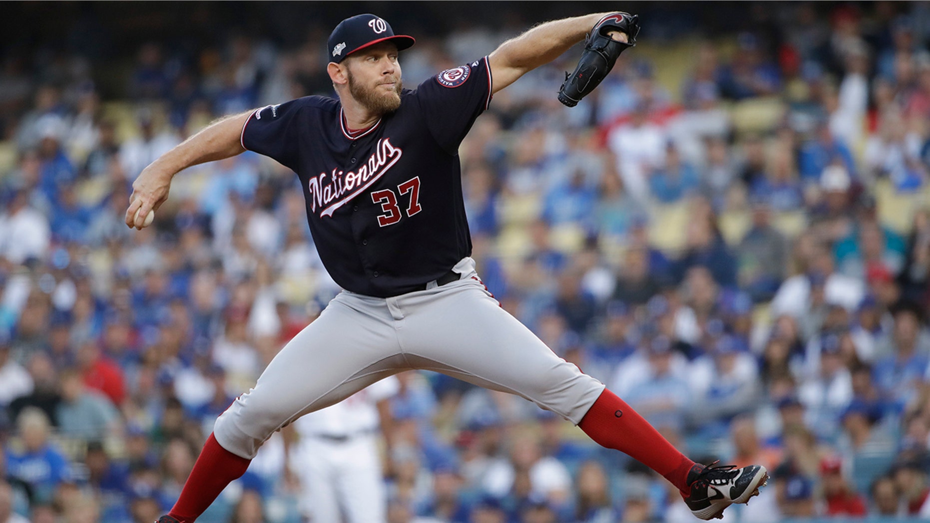 FILE - In this Oct. 9, 2019, file photo, Washington Nationals starting pitcher Stephen Strasburg throws to a Los Angeles Dodgers batter during the first inning in Game 5 of a baseball National League Division Series, in Los Angeles. World Series MVP Stephen Strasburg is staying with the Washington Nationals. The right-hander has agreed to a record $245 million, seven-year contract, a person familiar with the negotiations told The Associated Press on Monday, Dec. 9, 2019. The person spoke on condition of anonymity at baseball's annual winter meetings because the agreement had not been announced. (AP Photo/Marcio Jose Sanchez, File)