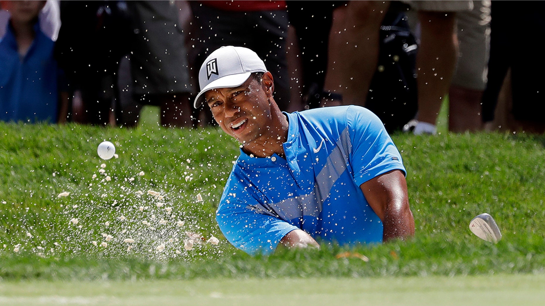 FILE - In this Thursday, Aug. 15, 2019 file photo, Tiger Woods hits from a sand trap on the fourth hole during the first round of the BMW Championship golf tournament at Medinah Country Club in Medinah, Ill. Woods is in the Bahamas this week as a player and a host, and in Australia next week as a player and Presidents Cup captain. (AP Photo/Nam Y. Huh, File)