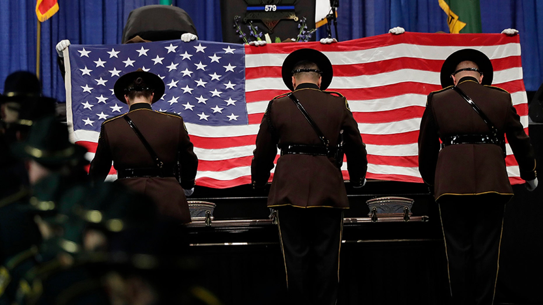 Pierce County Sheriff's deputies fold the U.S. flag that draped the casket of Pierce County Sheriff's Deputy Cooper Dyson, on Monday, Dec. 30, during a memorial service in Tacoma, Wash. (AP)