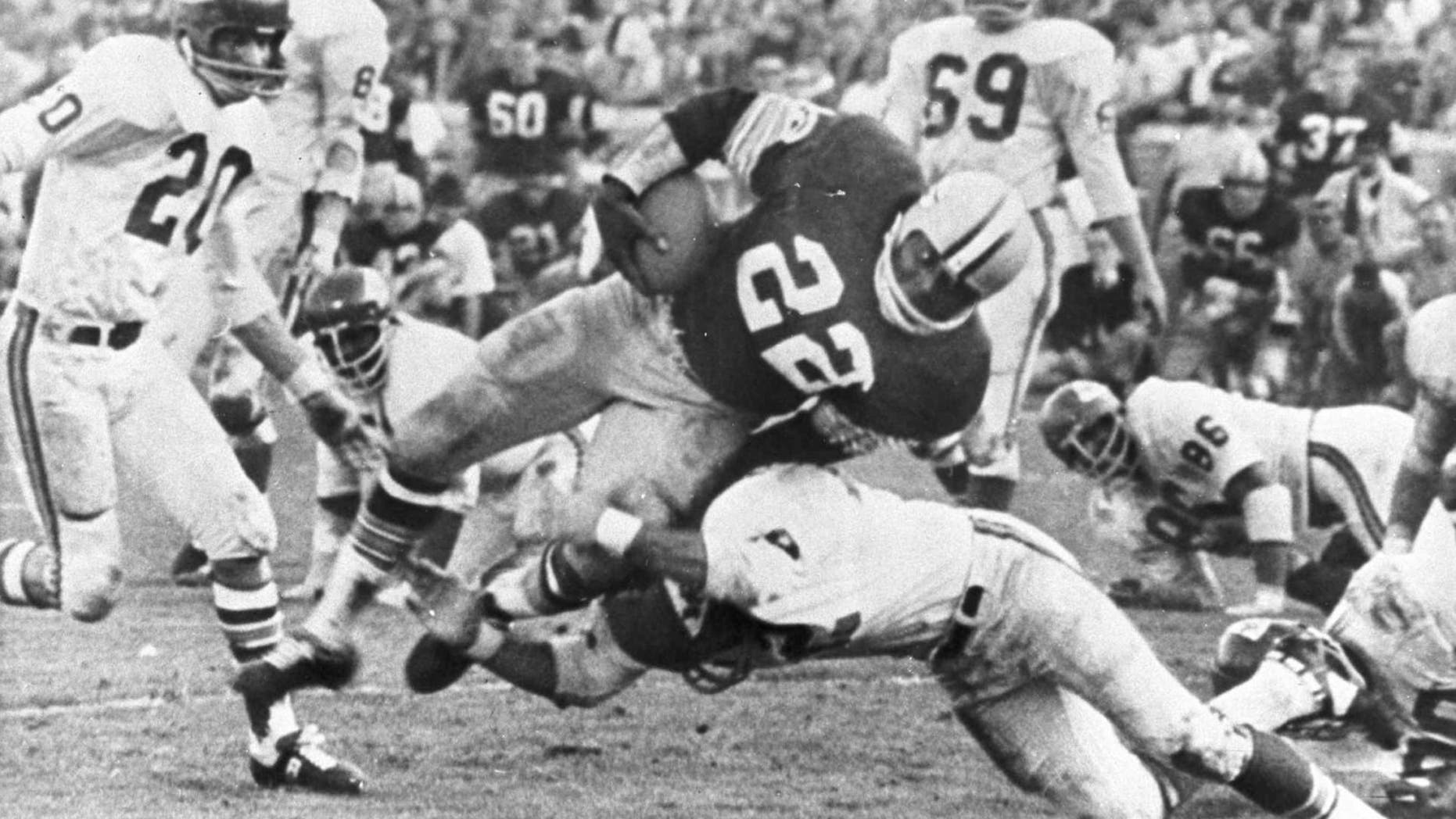 The Packers' Klijah Pitts (22) goes over right tackle to the Chiefs' five-yard line, a six-yard gain, before being brought down by Kansas City's Johnny Robinson in the fourth quarter of the Super Bowl game in Los Angeles Jan. 15, 1967. Three plays later Pitts went over for the touchdown as the Packers beat the Chiefs 35 to 10. Others include Bobby Hunt (20) and Sherrill Headrick (69). (AP Photo)