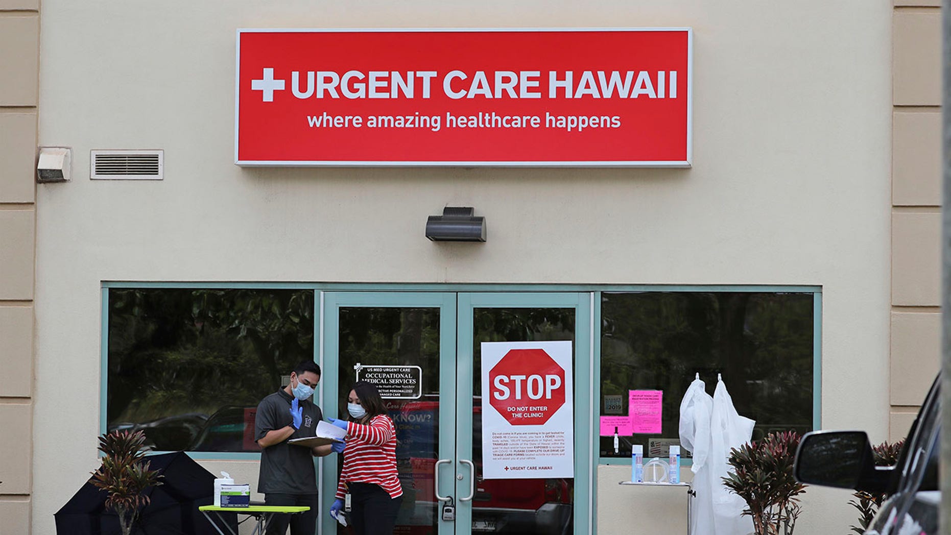 People wearing medical gear stand outside an Urgent Care Hawaii medical clinic March 13, 2019, in Pearl City, Hawaii. AP Photo/Marco Garcia)