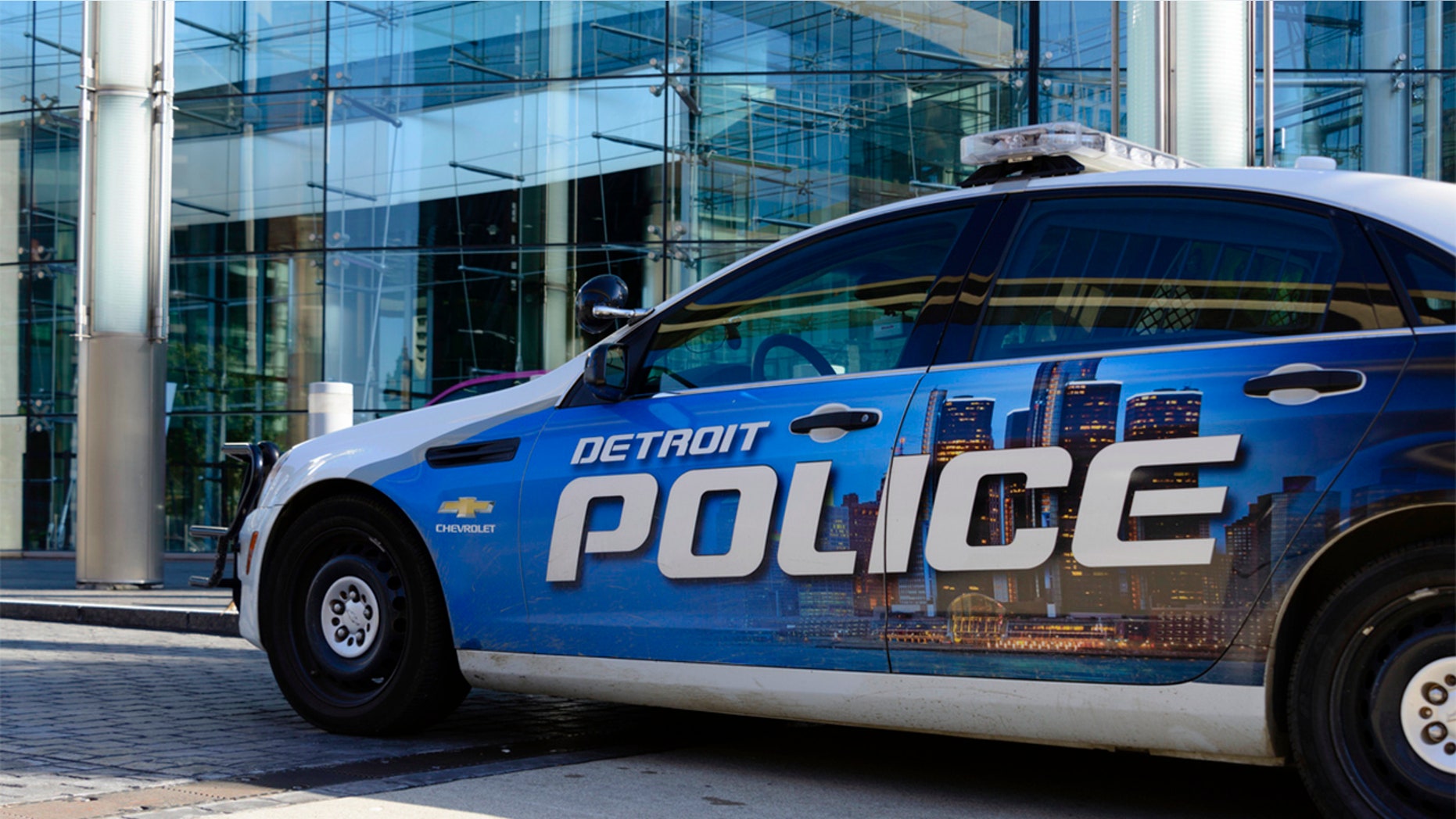 Detroit, Michigan, USA - 2016: A Detroit Police car parked in front of the Renaissance Center, world headquarters for GM in downtown Detroit.