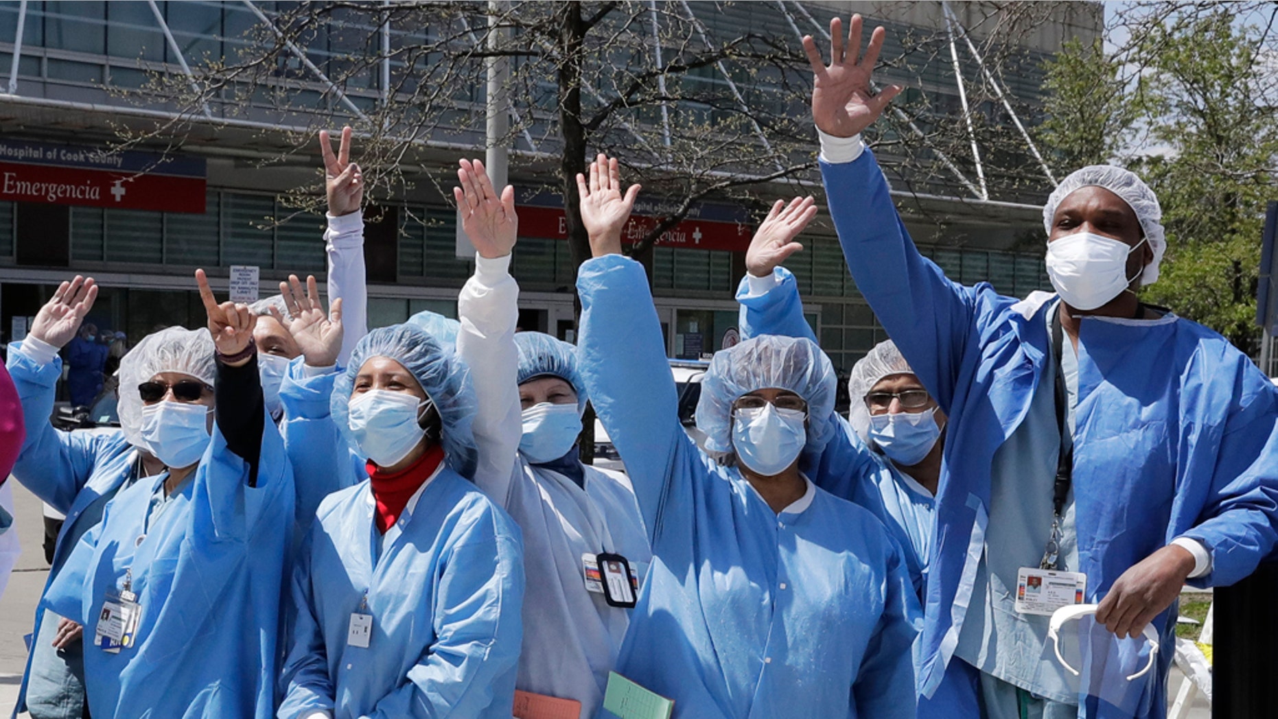 Healthcare workers at John H. Stroger, Jr. Hospital of Cook County clap and cheer as they watch the U.S. Navy's Blue Angels flight demonstration squadron fly over in Chicago, Tuesday, May 12, 2020. The flyover was a salute to first responders in the wake of the coronavirus pandemic. (AP Photo/Nam Y. Huh)