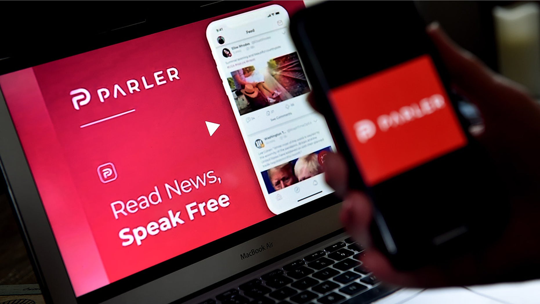 This illustration picture shows social media application logo from Parler displayed on a smartphone with its website in the background in Arlington, Virginia on July 2, 2020.