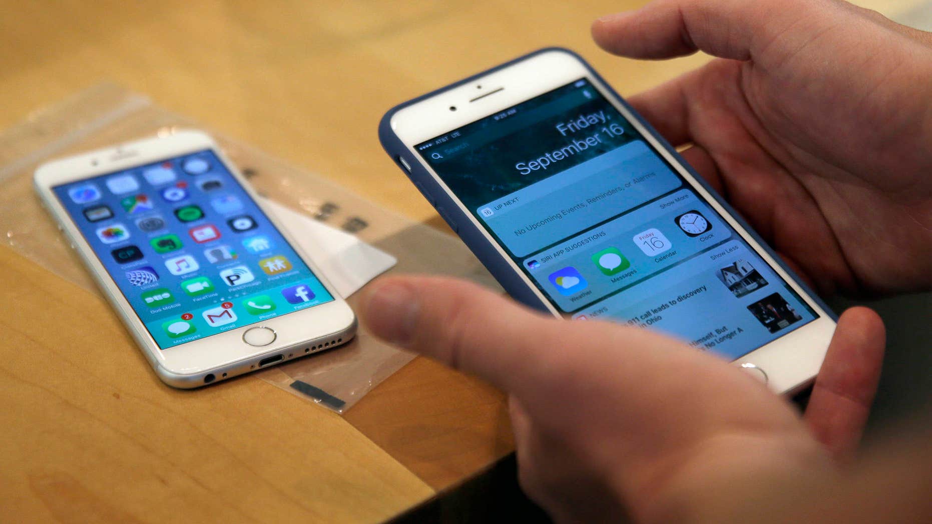 FILE - In this Friday, Sept. 16, 2016, file photo, a customer sets up his iPhone 7 Plus, right, as he switches from an iPhone 6. (AP Photo/Kiichiro Sato, File)