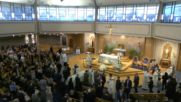 Jimmy Gracey's casket draped in white cloth during funeral mass