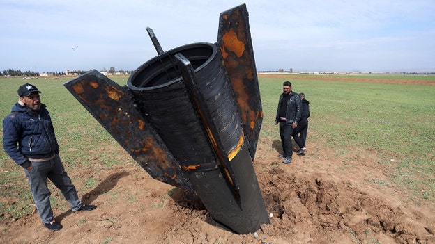 Hình ảnh gây ấn tượng cho thấy người dân đứng cạnh một quả tên lửa bị rơi ở Syria gần sân bay.