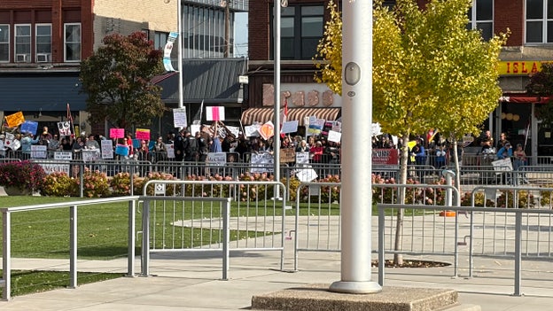 Protesters line up outside Trump rally Sunday in Michigan
