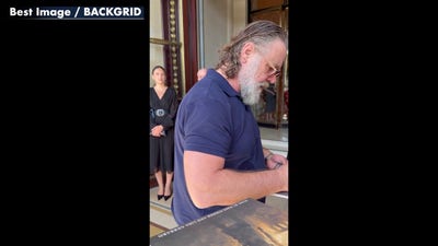 Russell Crowe snaps at swarming fans outside Paris hotel