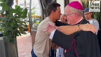 Mark Wahlberg prays with bishop at the opening of his new restaurant