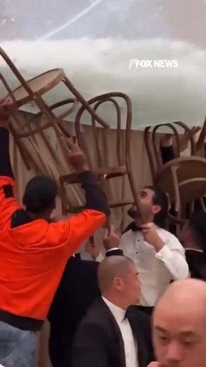 Wedding guests use chairs to stop venue from flooding