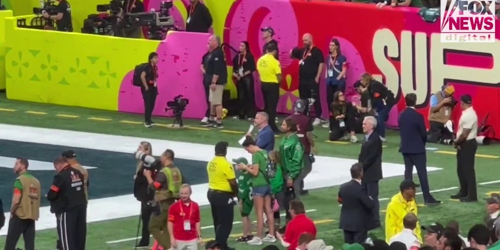 Bradley Cooper standing on the sidelines at the Super Bowl