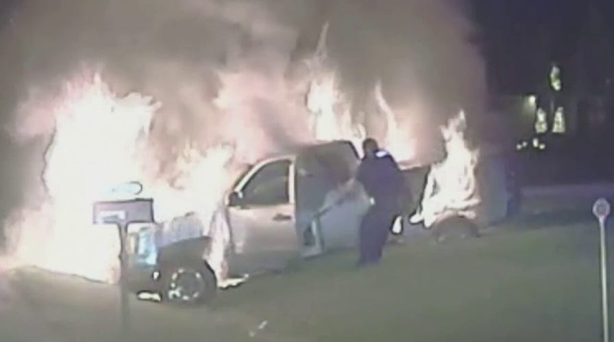 Michigan police officer saves woman trapped inside burning pickup truck, video shows