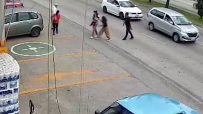 Store manager dives into oncoming traffic to save little girl