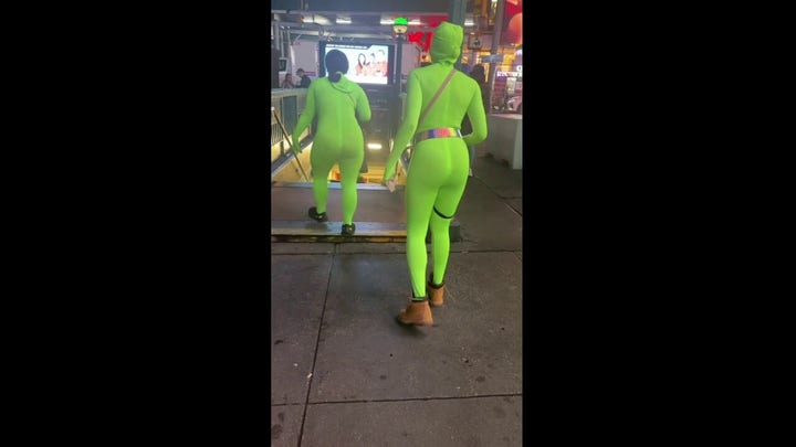 Women in neon green bodysuits exit the subway after allegedly assaulting passengers on the Manhattan subway