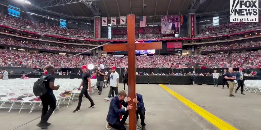 Worshippers at Charlie Kirk memorial bring cross to center of stadium floor
