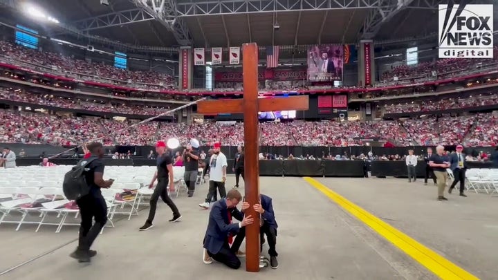 Worshippers at Charlie Kirk memorial bring cross to center of stadium floor