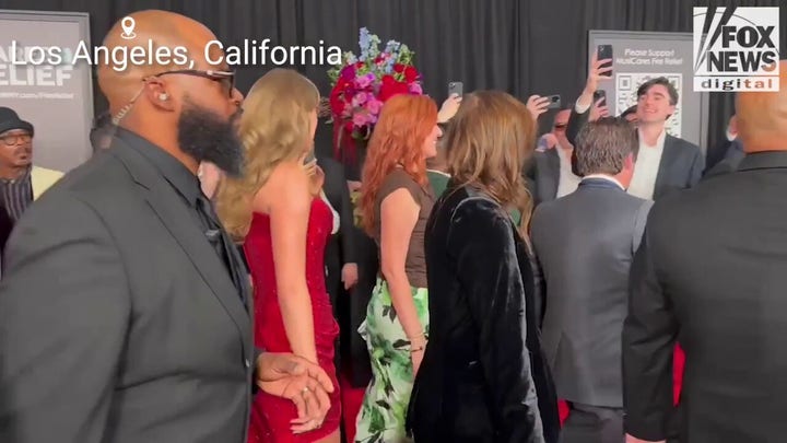 Taylor Swift deslumbra con un vestido rojo en la alfombra roja de los Premios Grammy 2025