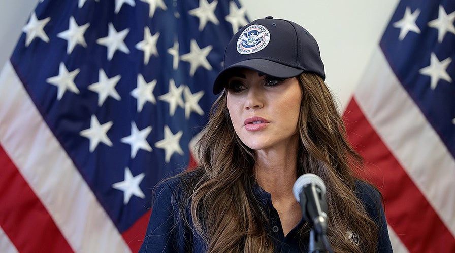  DHS Secretary Kristi Noem holds a property   league  to item   TSA agents