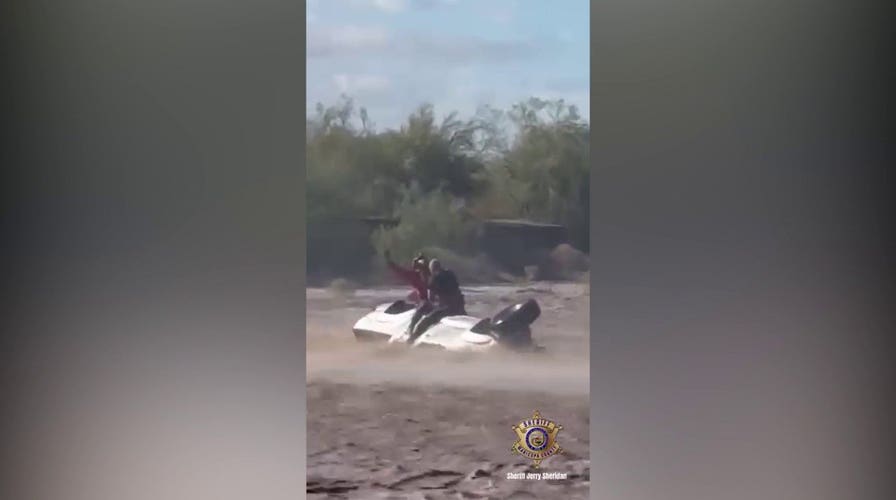 Helicopter crew hoists man to safety as floodwaters engulf overturned truck