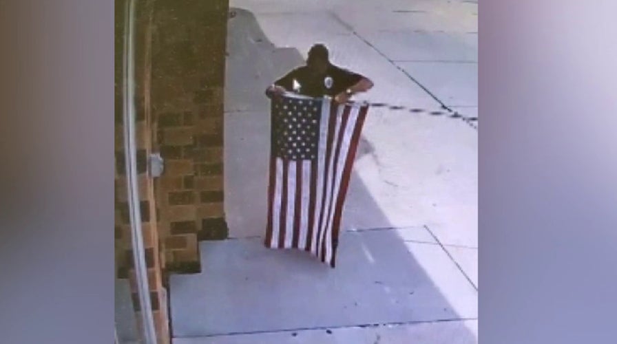 Raw Video: Police officer stops to fix fallen flag outside Nebraska business