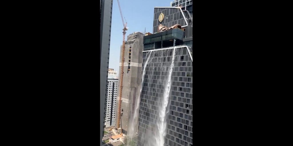 Water cascades down side of building in Bangkok following earthquake