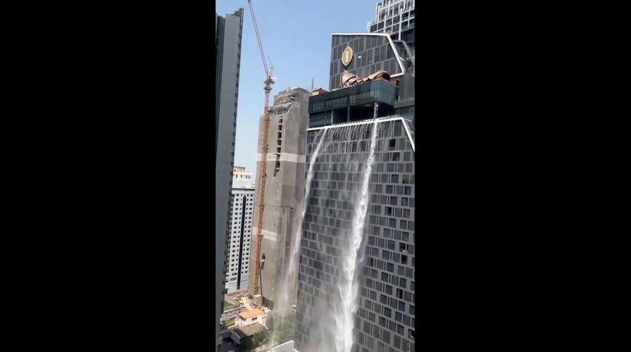 Water cascades down side of building in Bangkok following earthquake