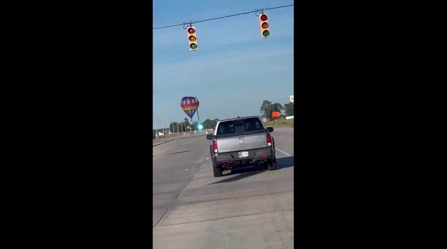 Bystander captures hot air balloon hitting power line, causing blue spark