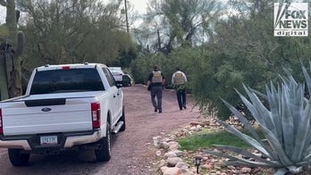 Sheriff's office deputies walk up driveway of house in area of Nancy Guthrie's house