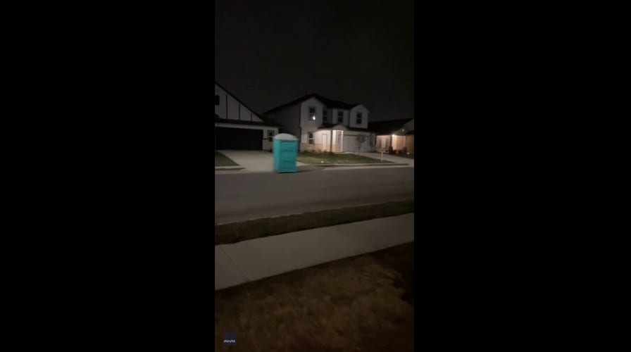 Portable toilet glides down Texas street during storm