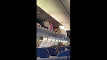 Woman spotted lying inside luggage compartment before flight takes off