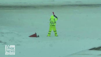 Airport employee seen killing time by playing with marshaling wands