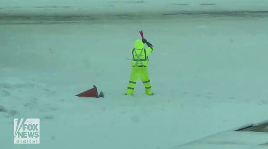 Airport employee seen killing time by playing with marshaling wands